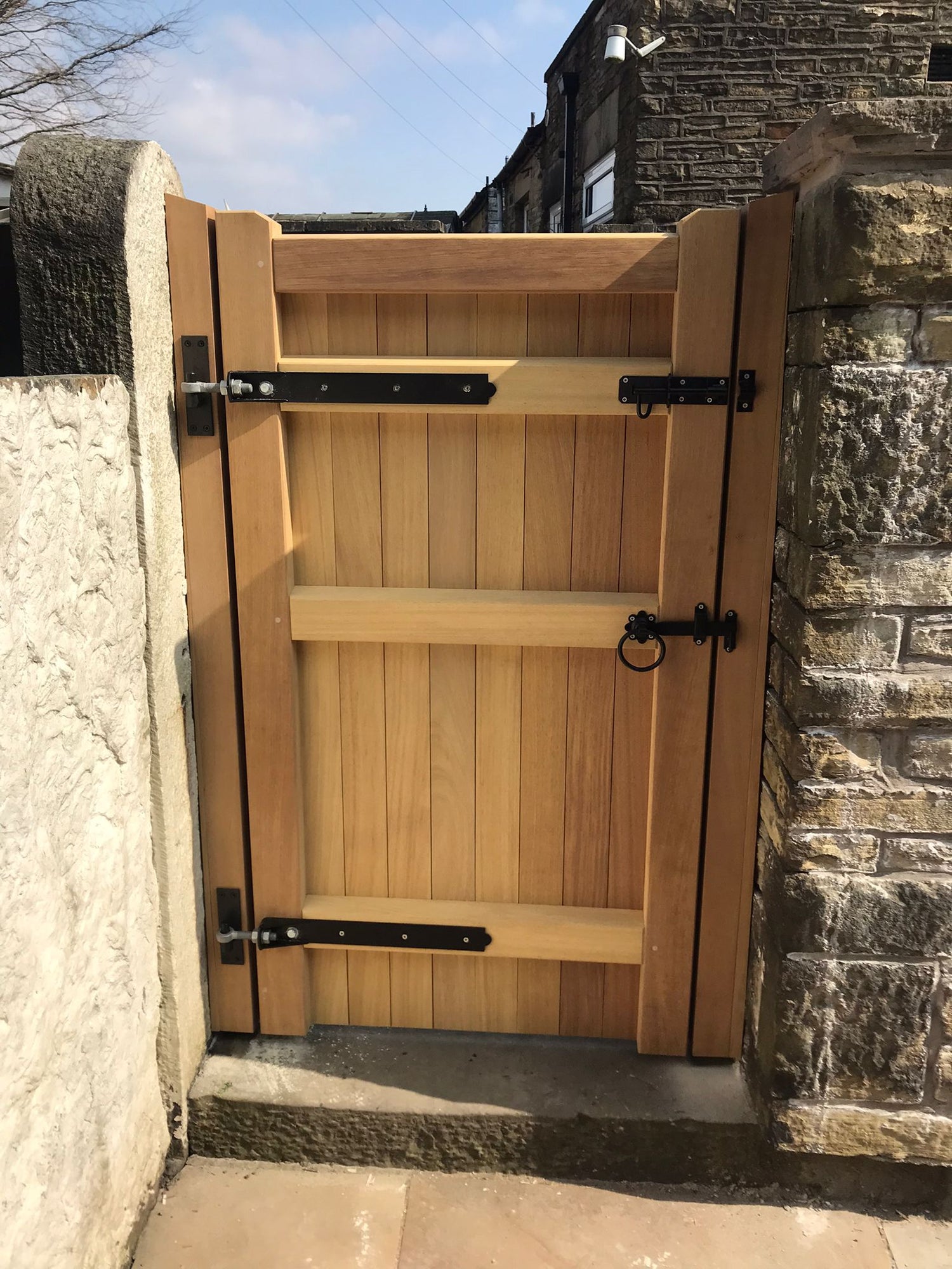 An Iroko hardwood single gate in a village design