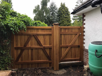 An Iroko hardwood gate and fence panel in a village design