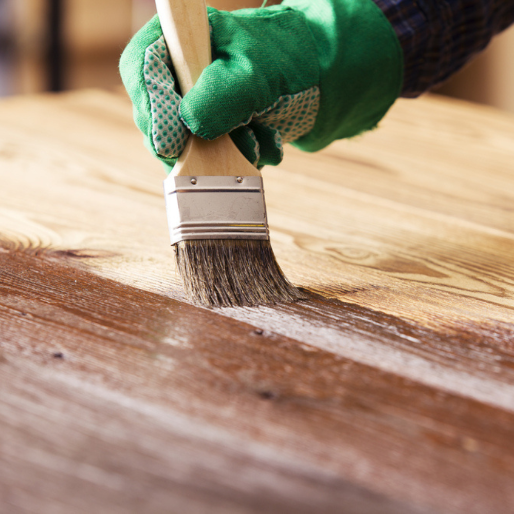 Person painting a wooden gate
