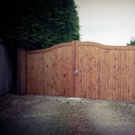 A huge double wooden gate with a curved top