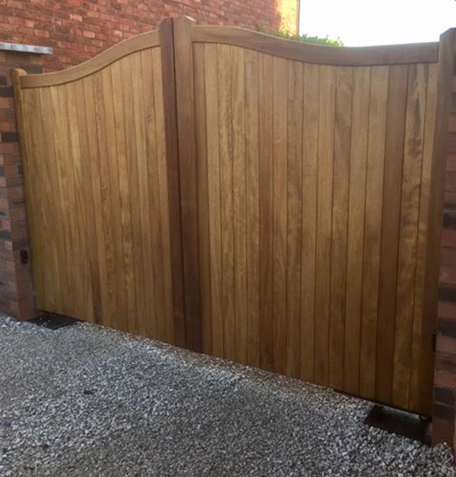 A hardwood double driveway gate with a curved top